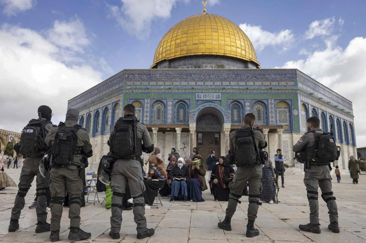 Israeli police in front of Muslim women praying in front of the Dome of the Rock while a group of Jewish. Photo Credit: AFP.